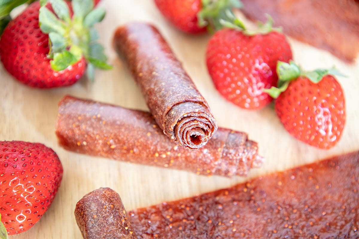 Kombucha Scoby Strawberry Fruit Roll-Ups on s cutting board.