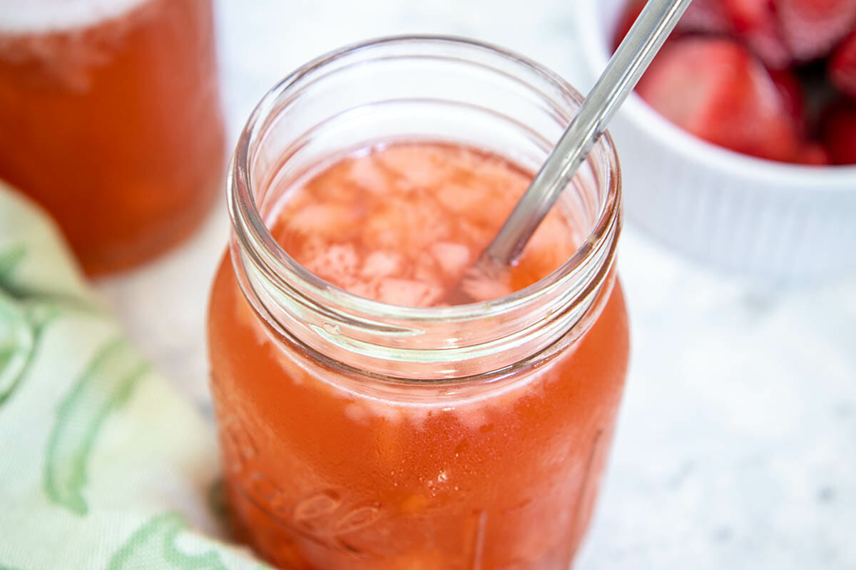 Strawberry Green Tea Kombucha in mason jar with straw.