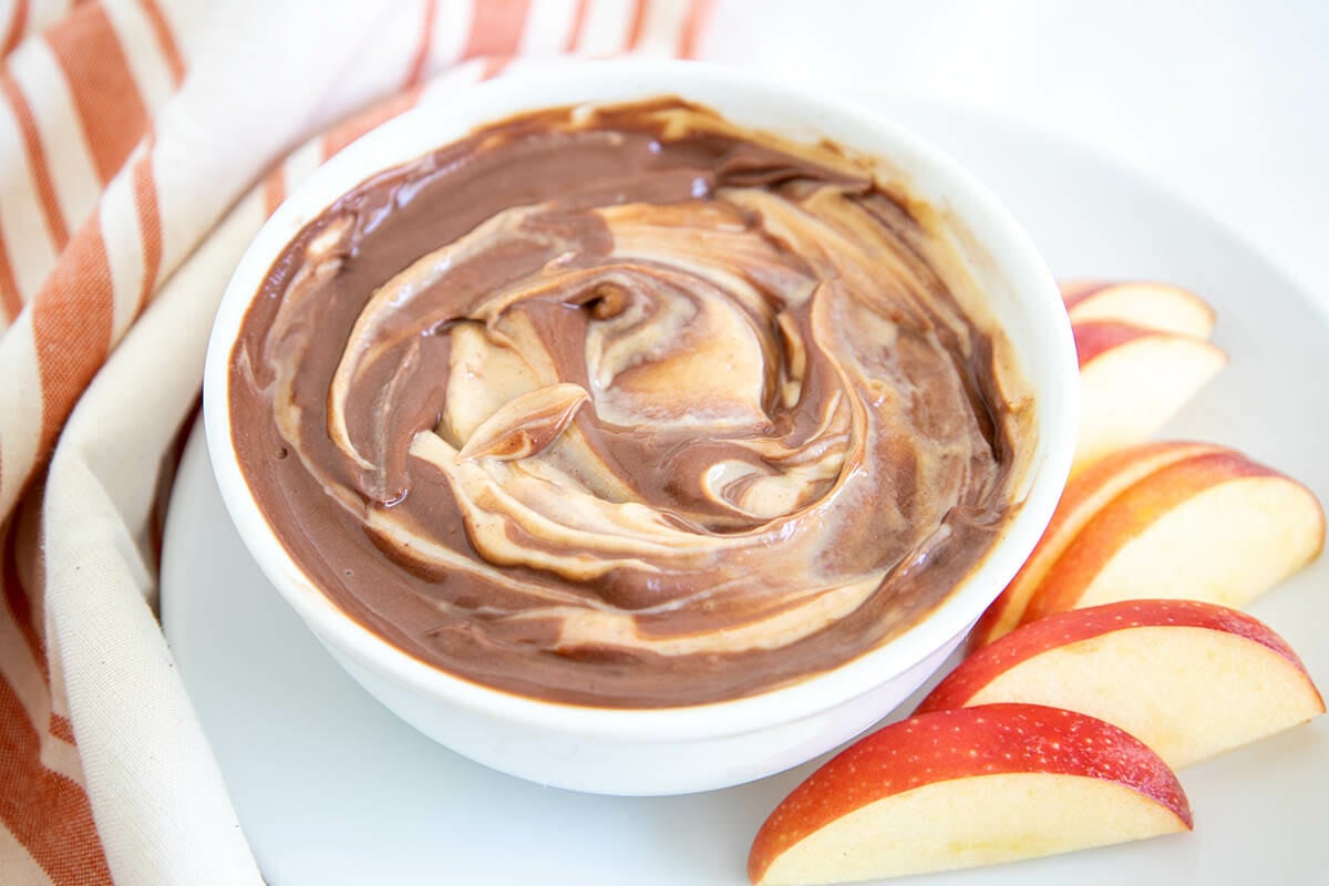 Chocolate Peanut Butter Dip in a bowl with apple slices.