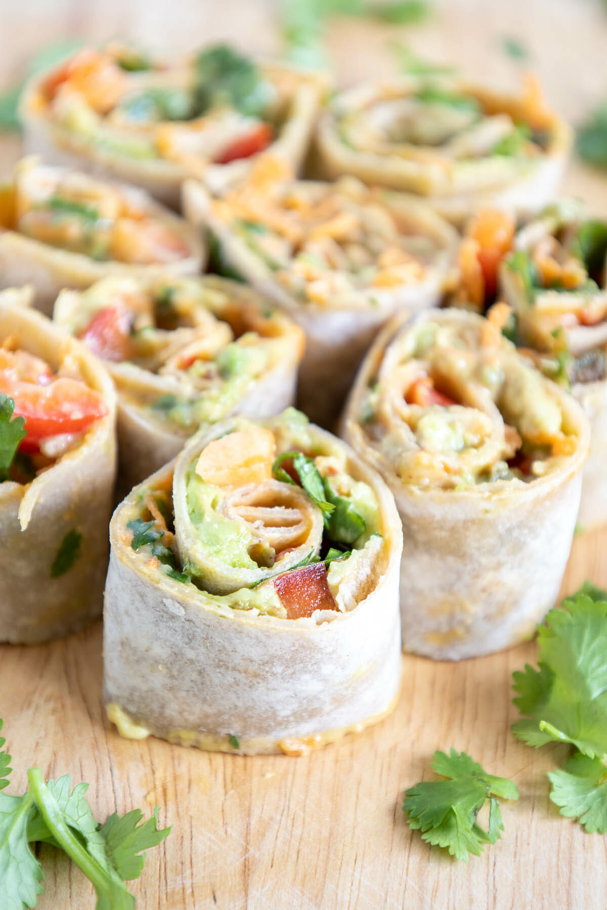 Thai Pinwheels with Peanut Sauce in a cutting board.