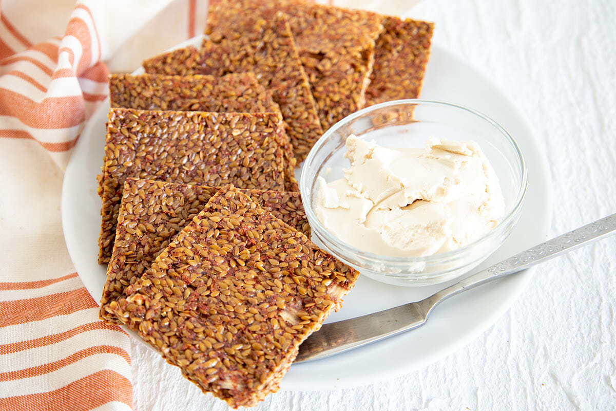 Dehydrated Pizza Crackers on plate with vegan cream cheese.