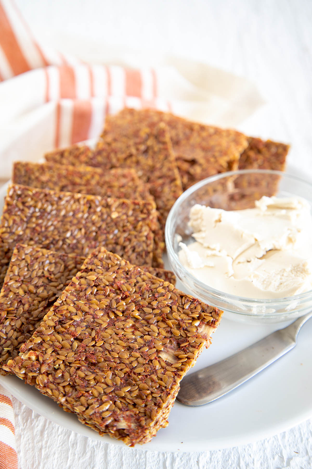 Dehydrated Pizza Crackers on plate with vegan cream cheese.