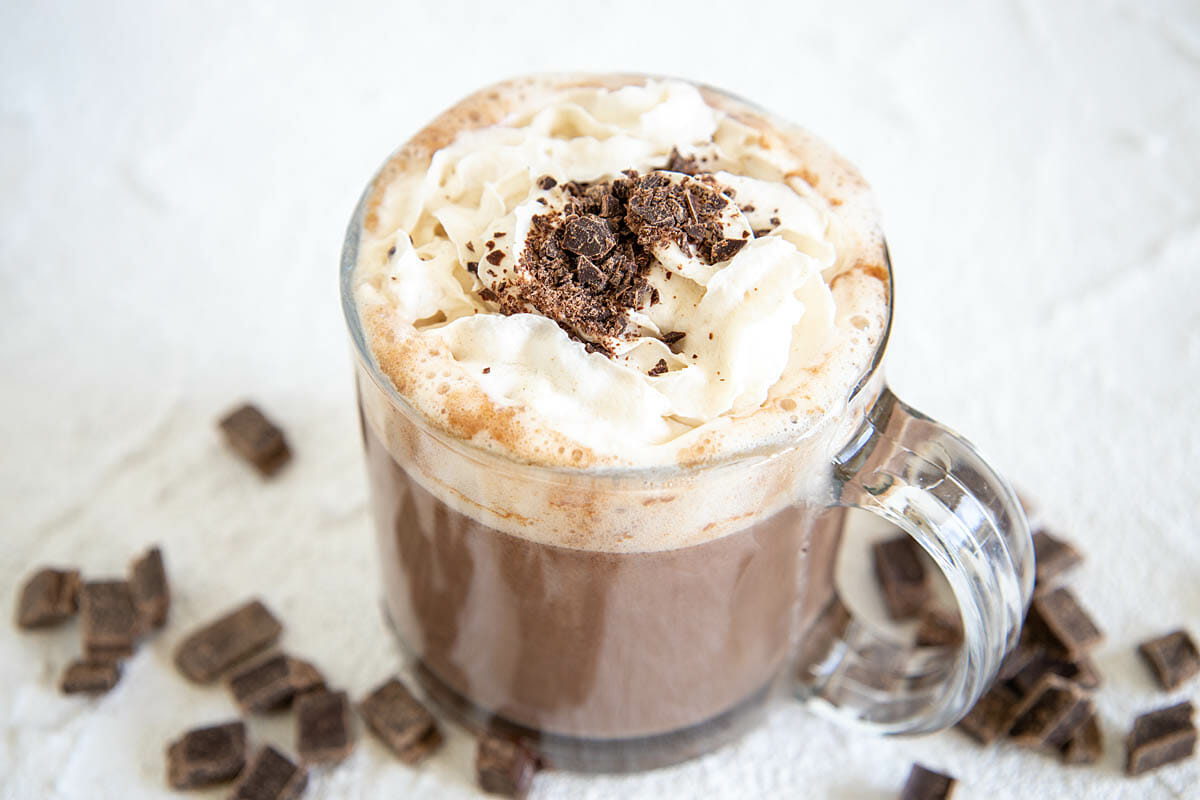 Vegan Hot Chocolate in a mug with dark chocolate chunks in the background.