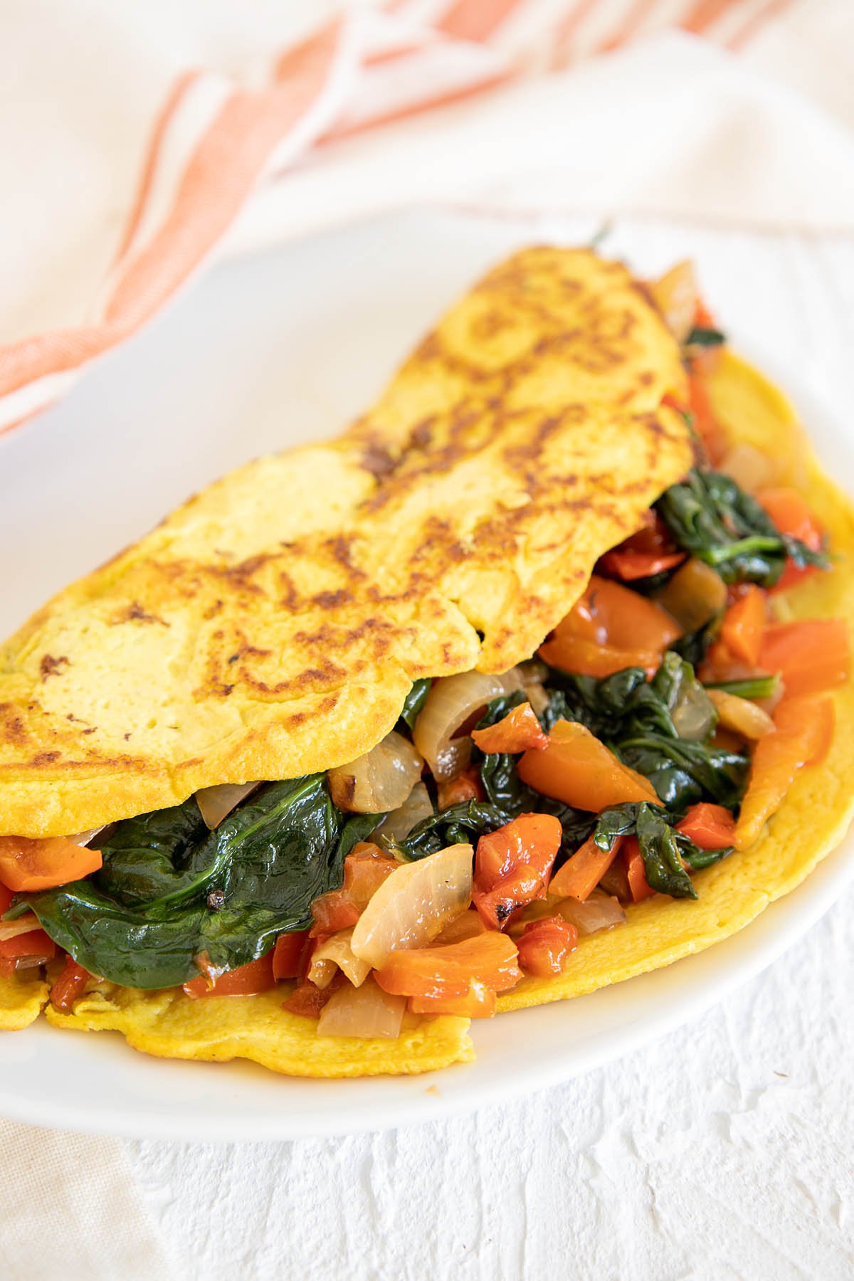 Vegan Tofu Omelette with veggies on a plate.