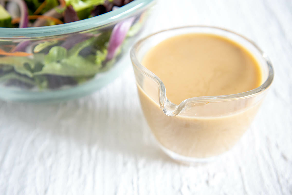 Vegan Honey Mustard Dressing next to salad.