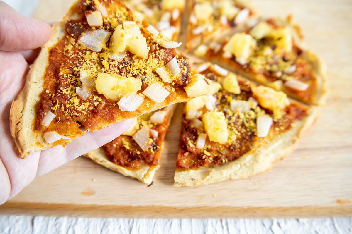 Slice of Chipotle Pizza with Pineapple and Onion in hand.