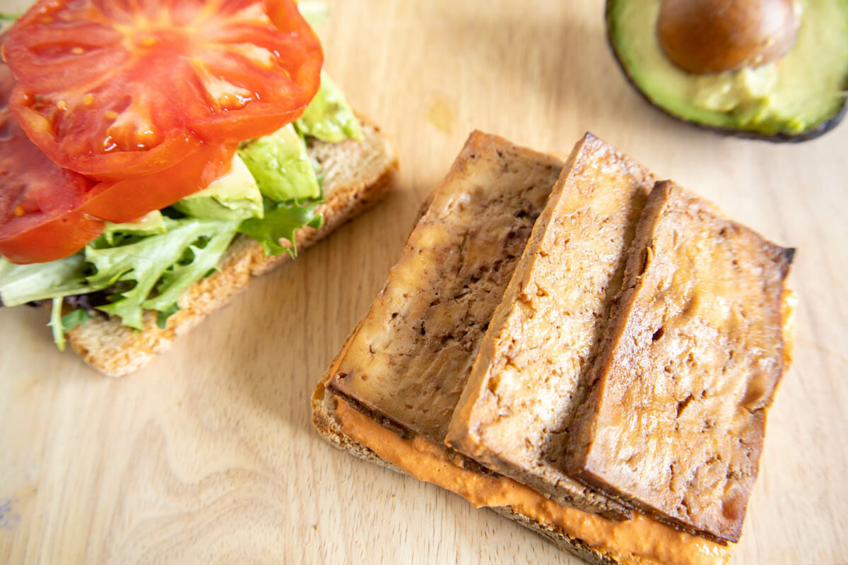 Tofu bacon on an open faced sandwich.