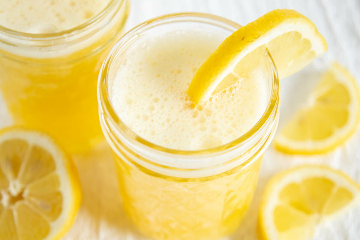 Mango Lemonade in two glasses with sliced lemon.