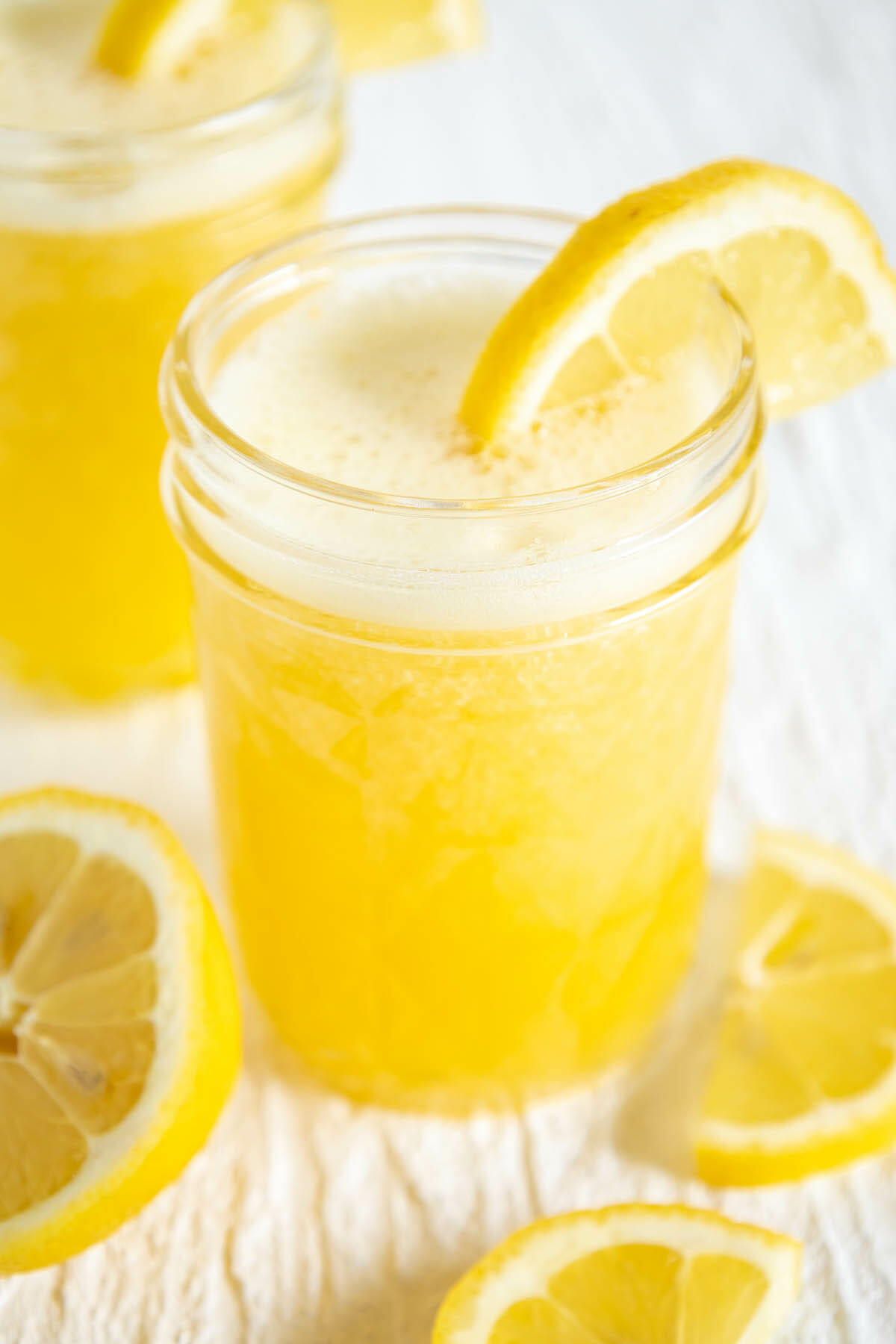 Mango Lemonade in two glasses with sliced lemons.