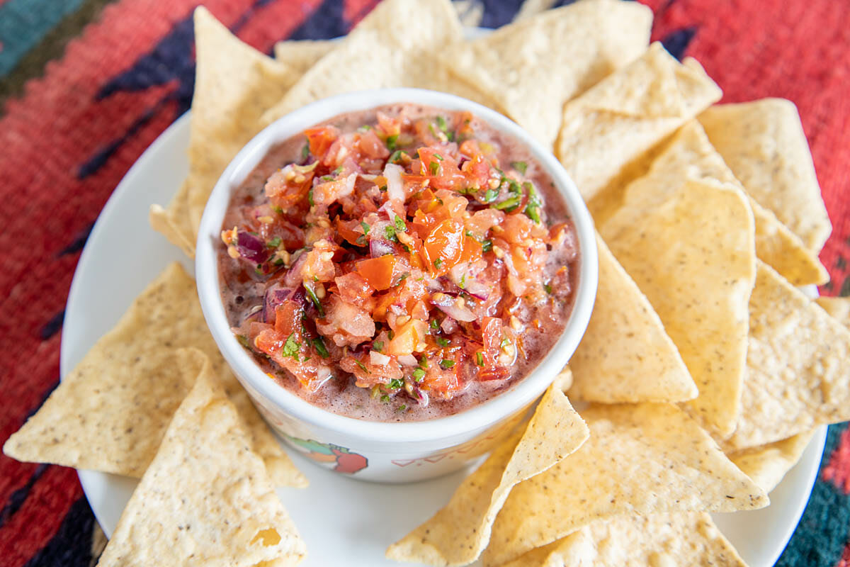 Serrano Salsa on a plate with tortilla chips.