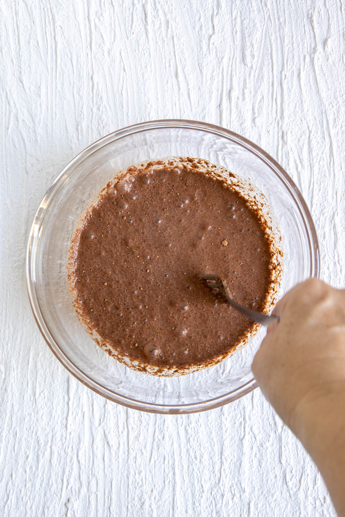 Wet ingredients in a bowl being whisked.