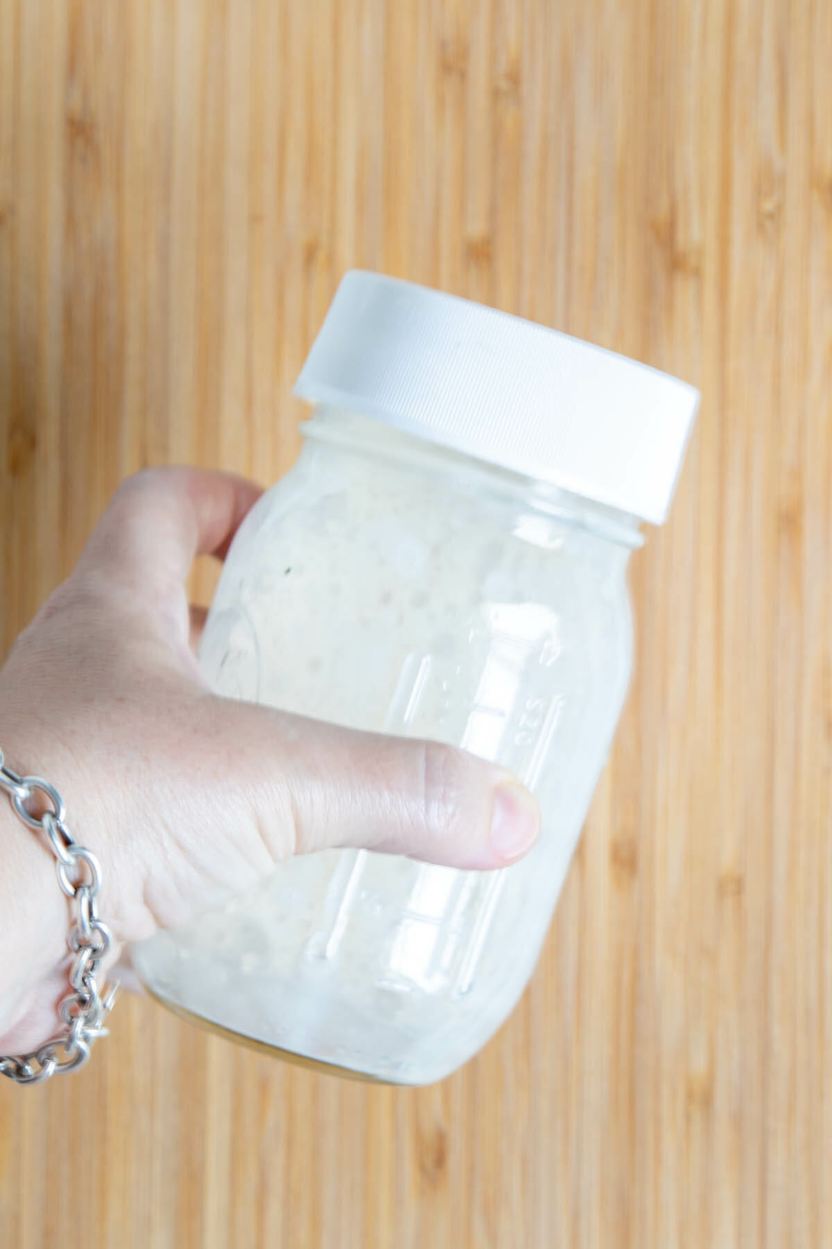 Soy milk being shaken in a mason jar.