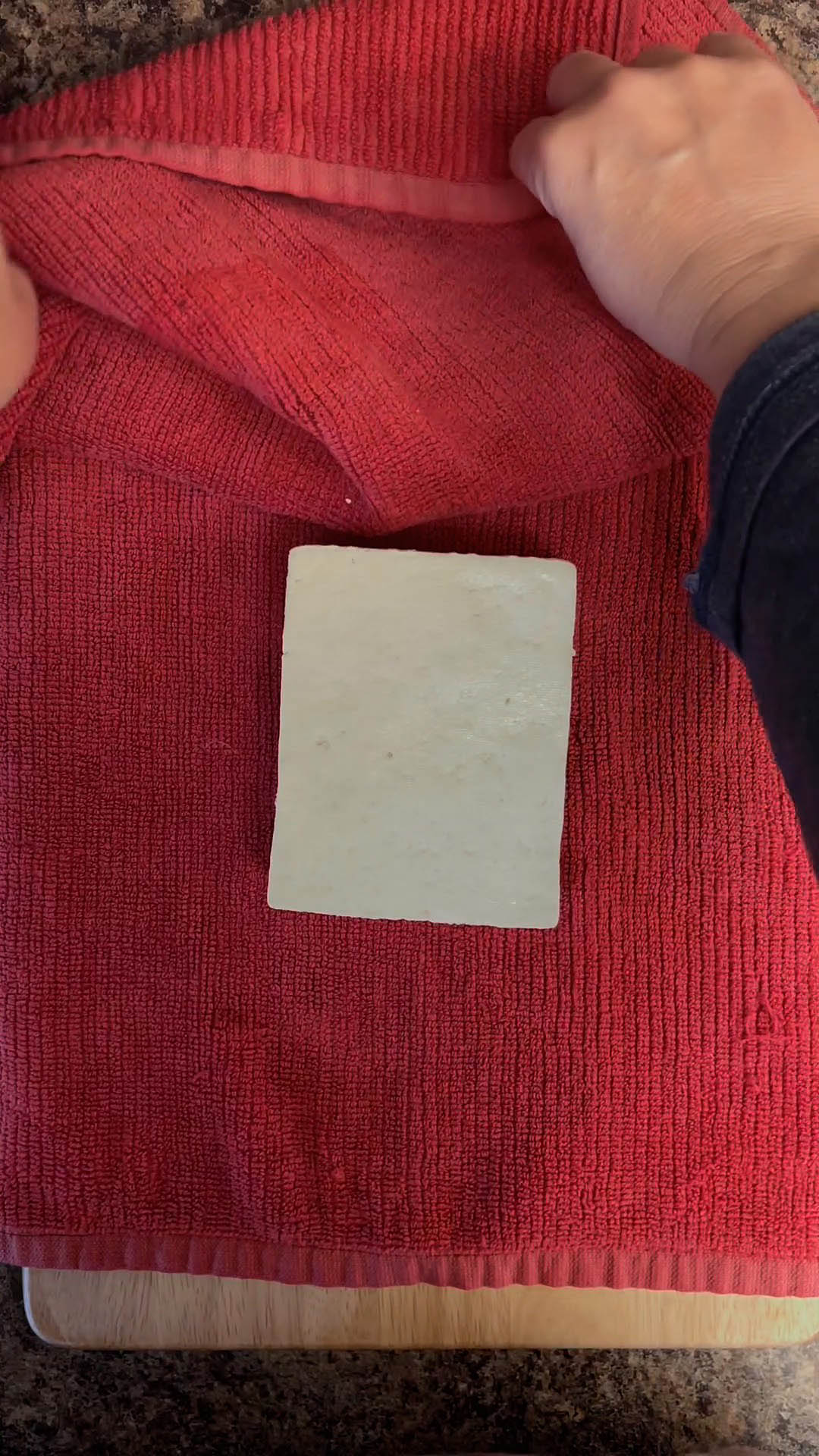 Block of tofu on a kitchen towel.