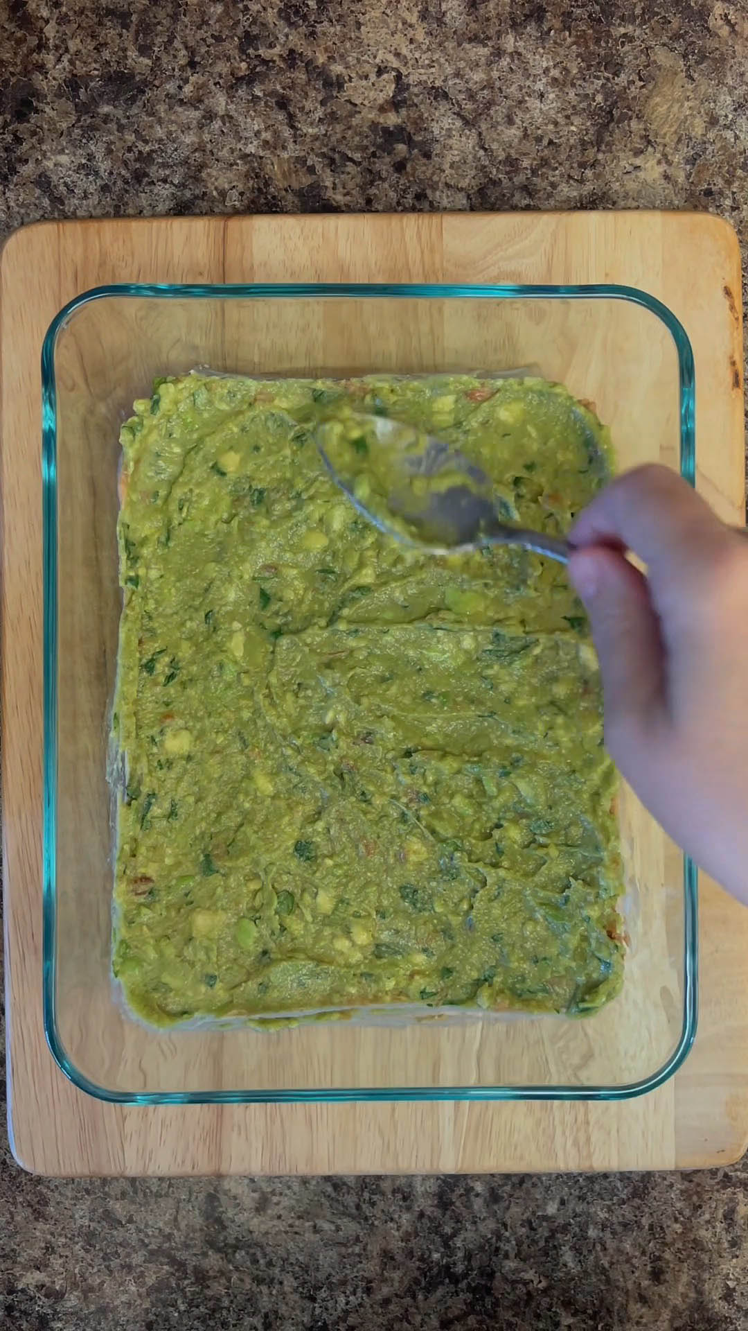 Guacamole spread on top of refried beans.
