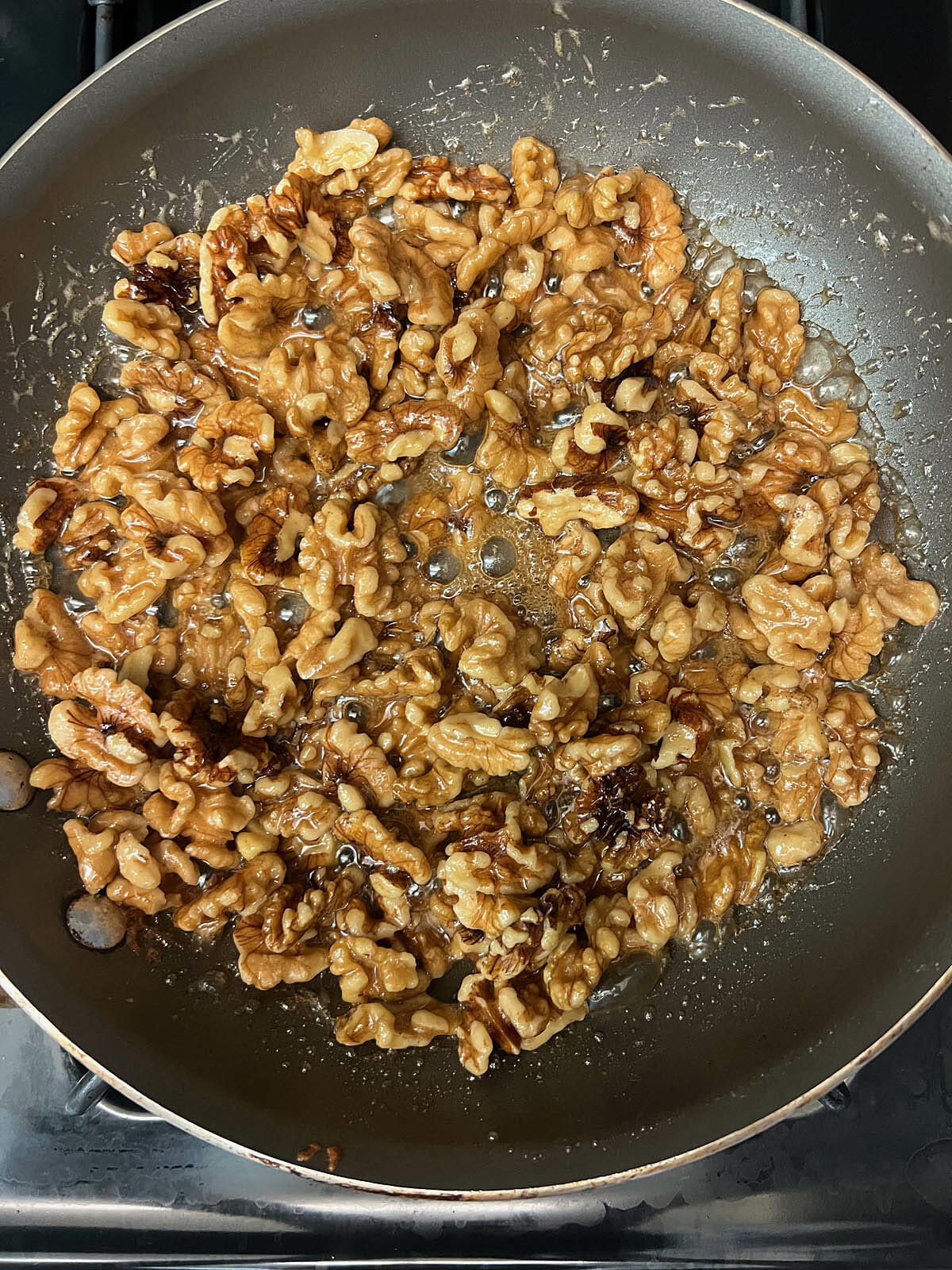 Walnuts, maple syrup, and salt in a pan.