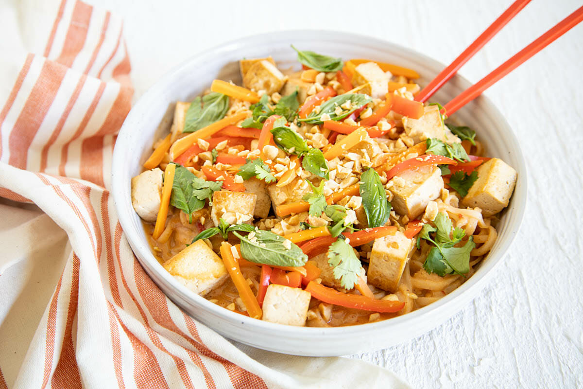 Tofu Thai Peanut Noodles in a bowl with napkin.