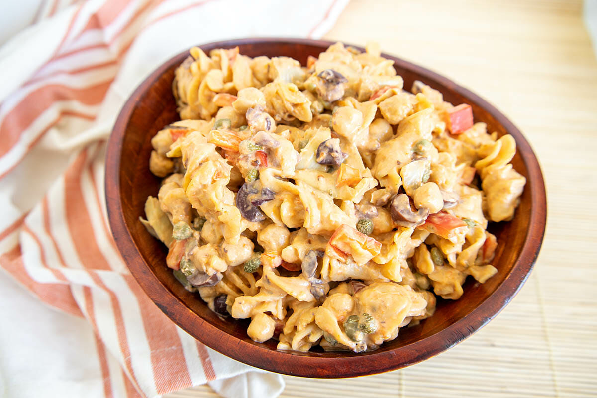 Red Lentil Pasta Salad with Chickpeas in a wood bowl with napkin.