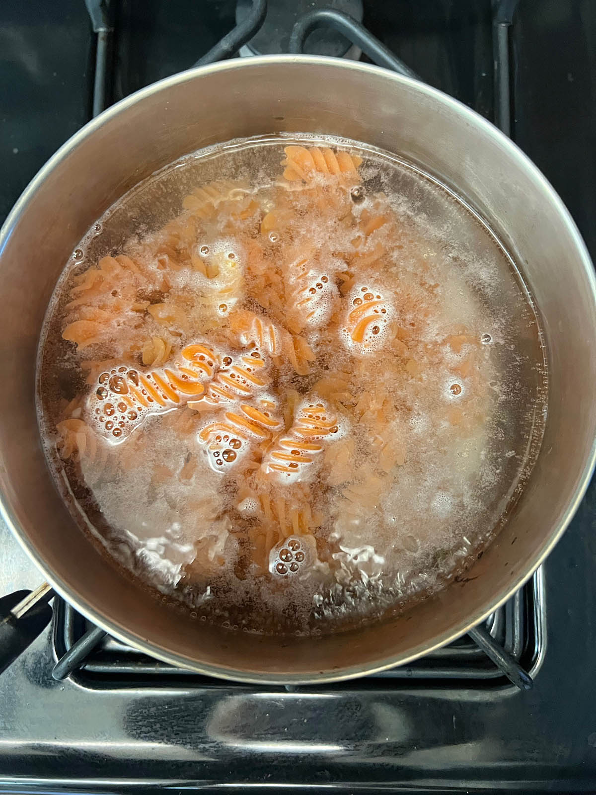 Red lentil pasta in boiling water.