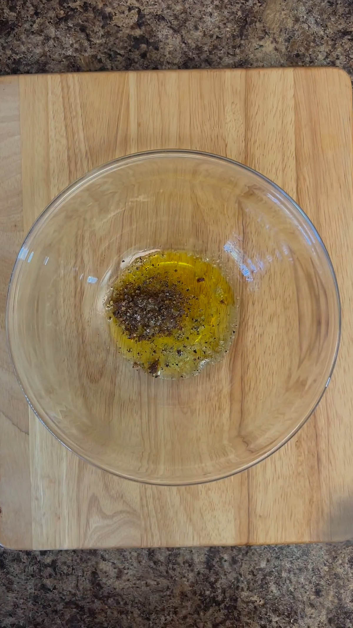Olive oil, sriracha powder, and salt and pepper in a bowl.