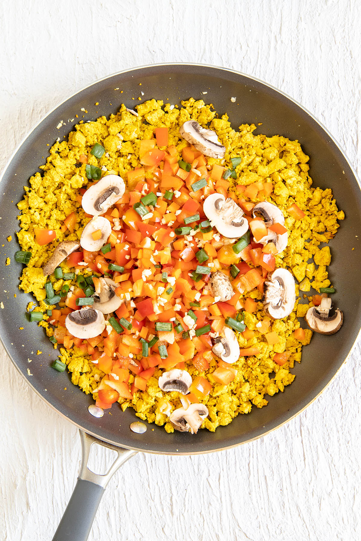 Tofu in a skillet with veggies.