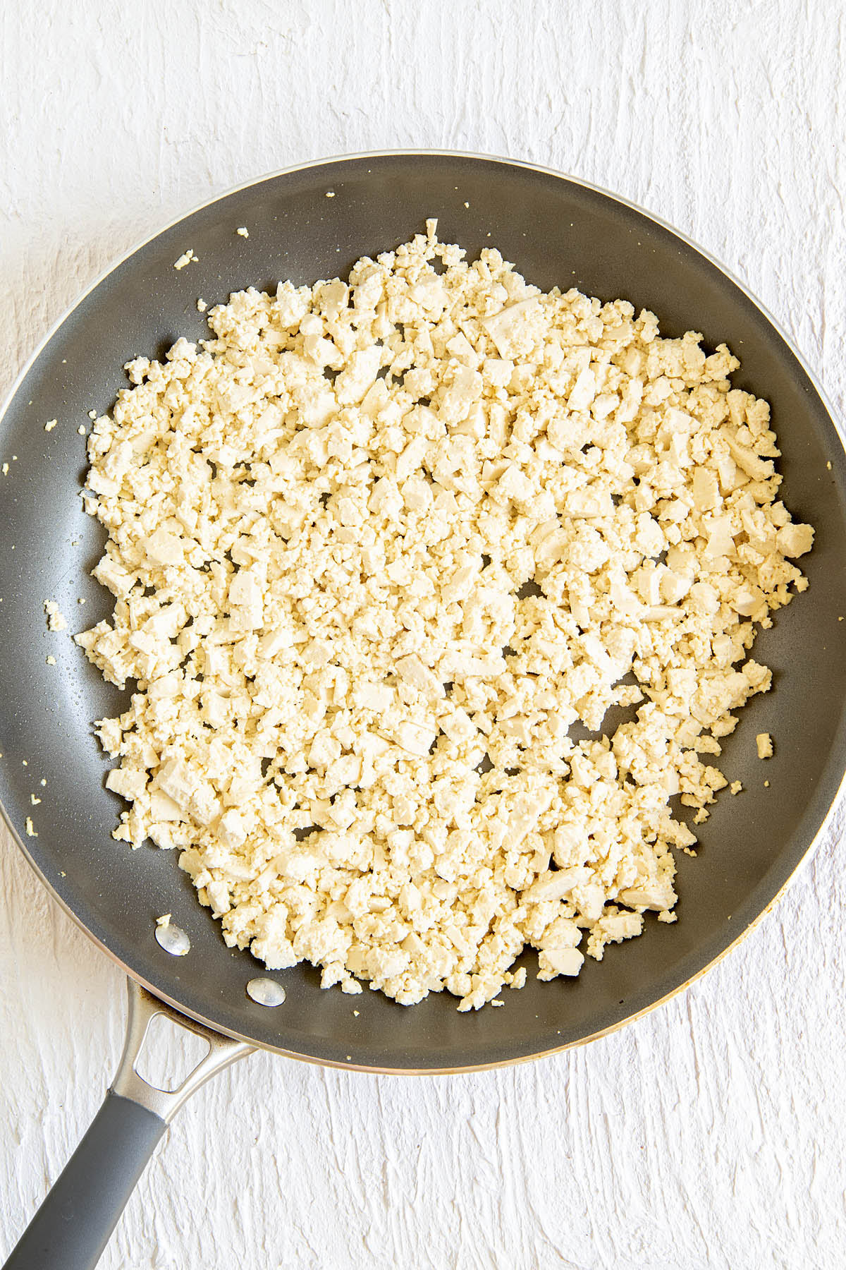 Tofu in a skillet with olive oil.