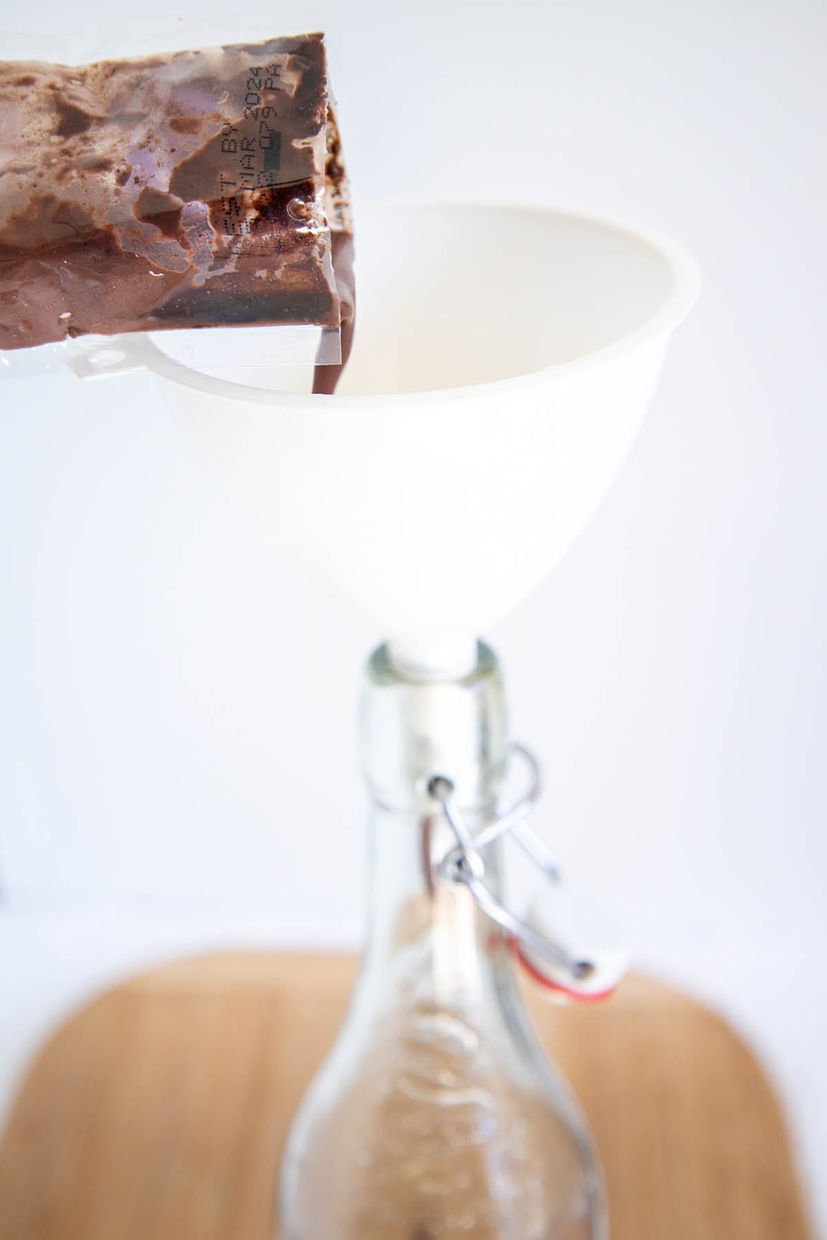 Acai puree being poured into funnel into a bottle.