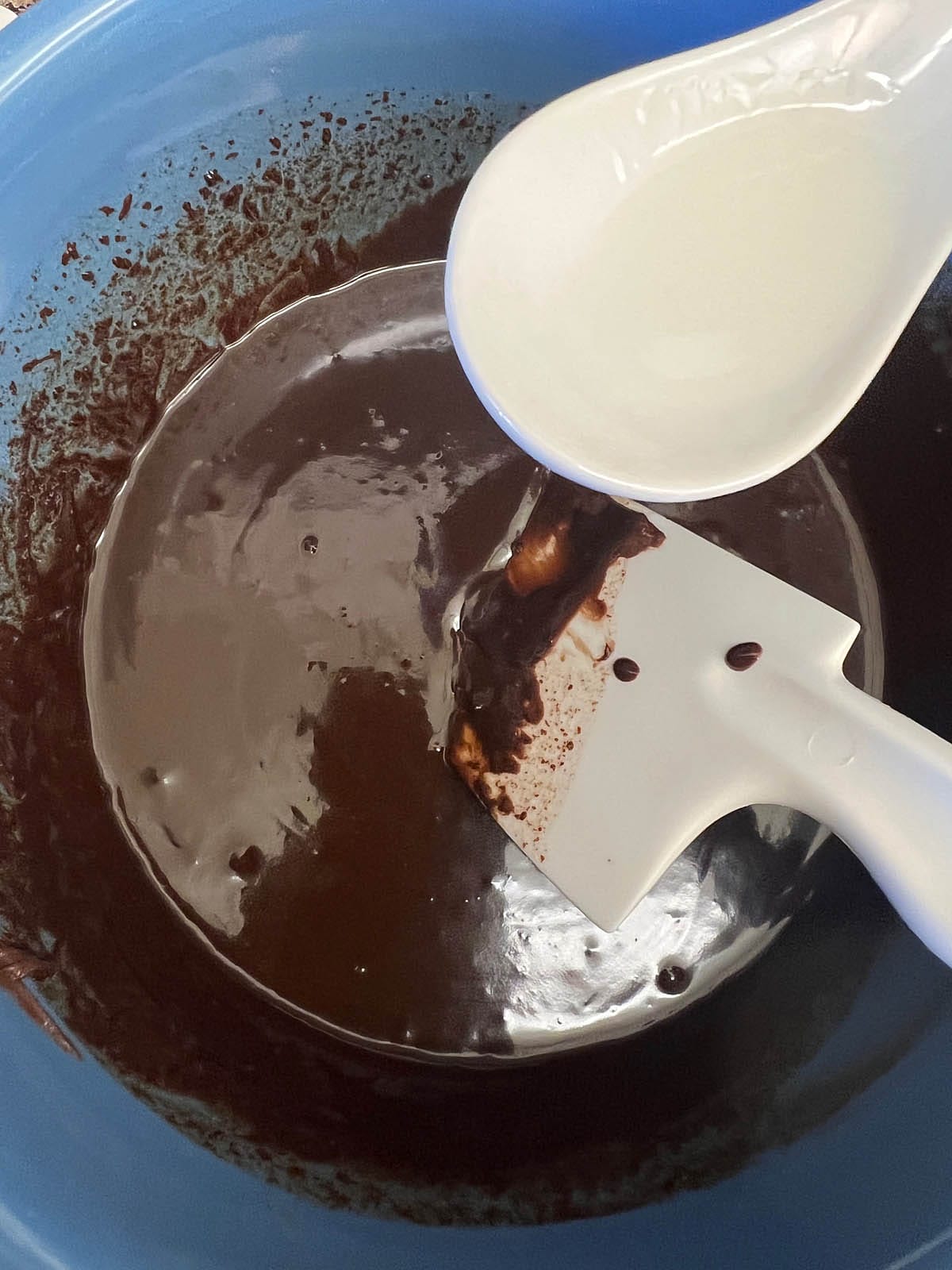 Peppermint extract being added to chocolate mixture.