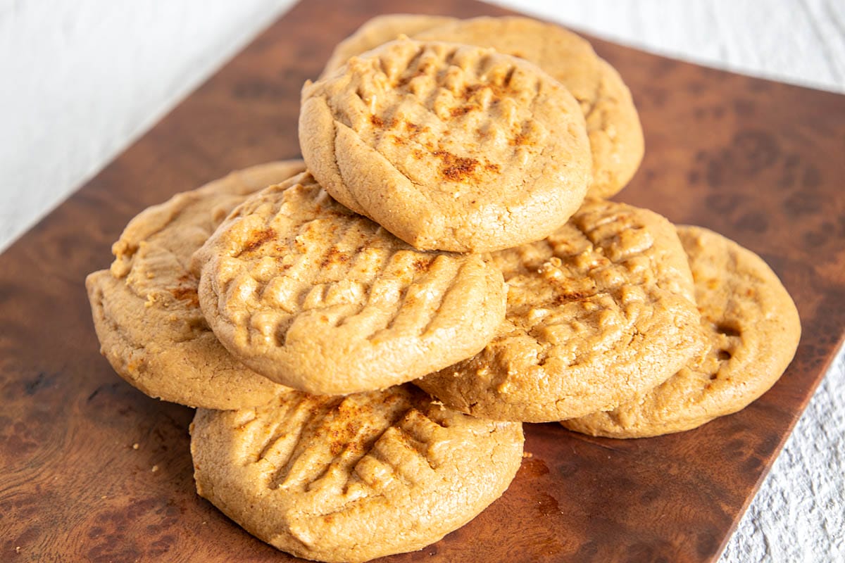 Spicy Peanut Butter Cookies stacked on a cookie sheet.