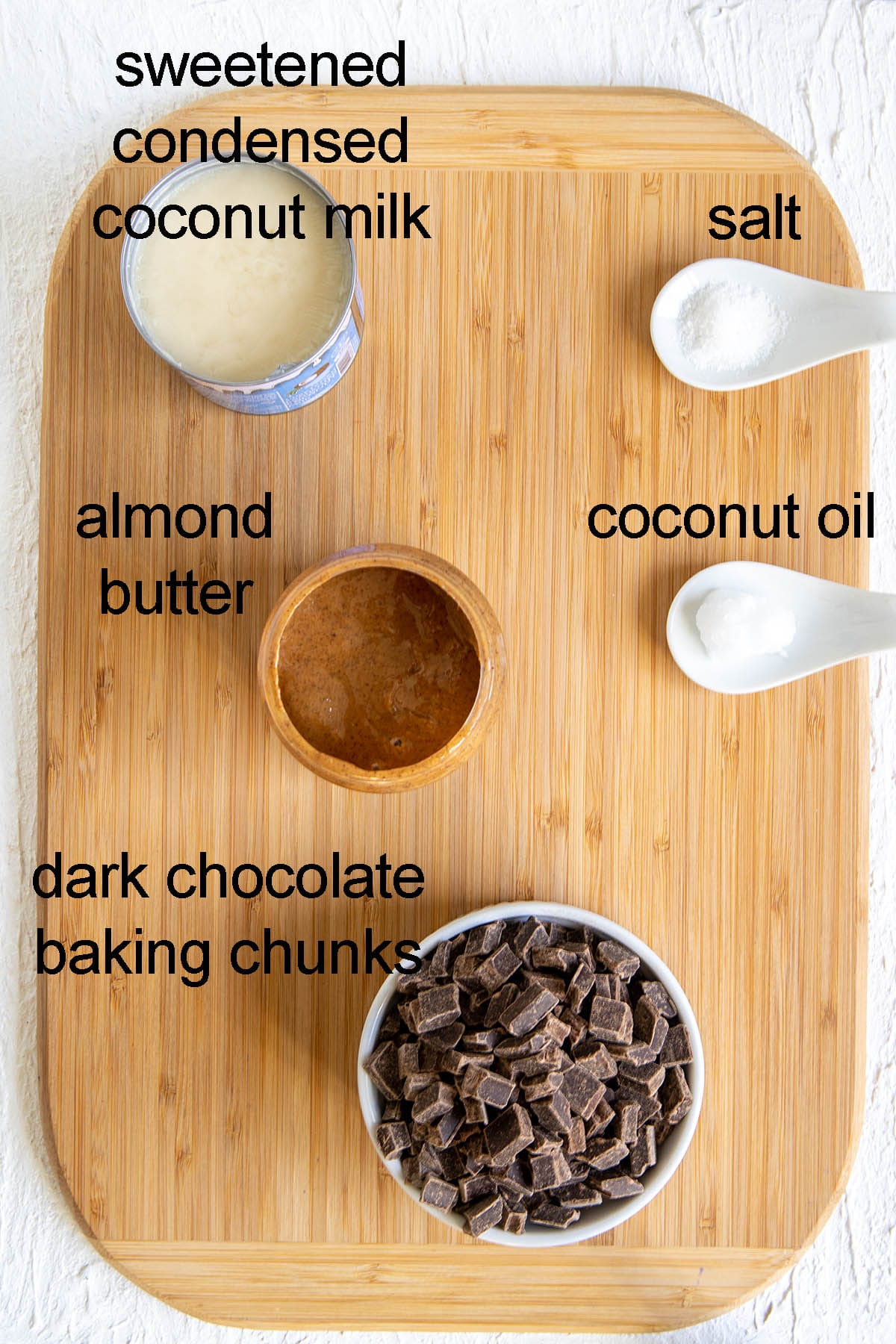 Ingredients for chocolate almond butter cups on a cutting board with labels.