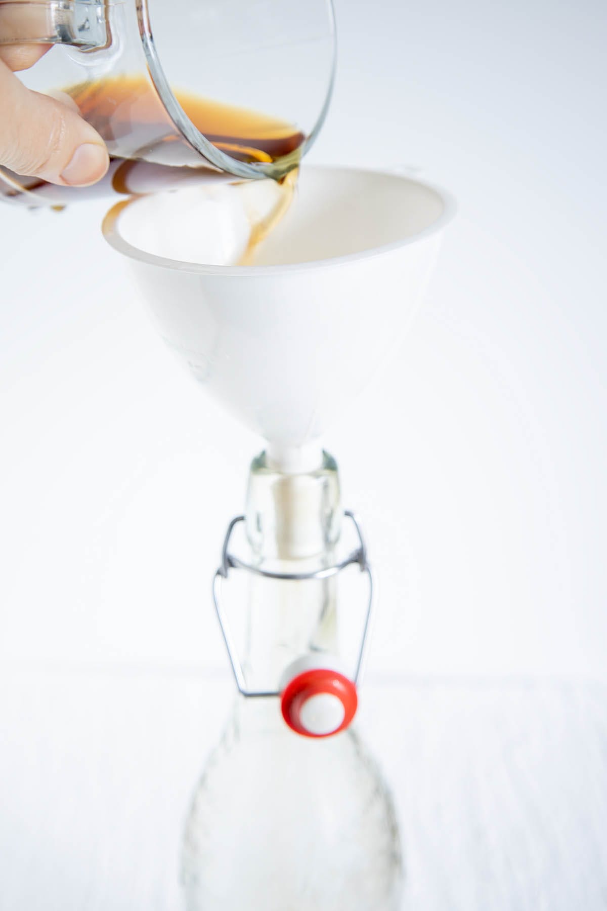 Coffee being poured into a funnel into a bottle.