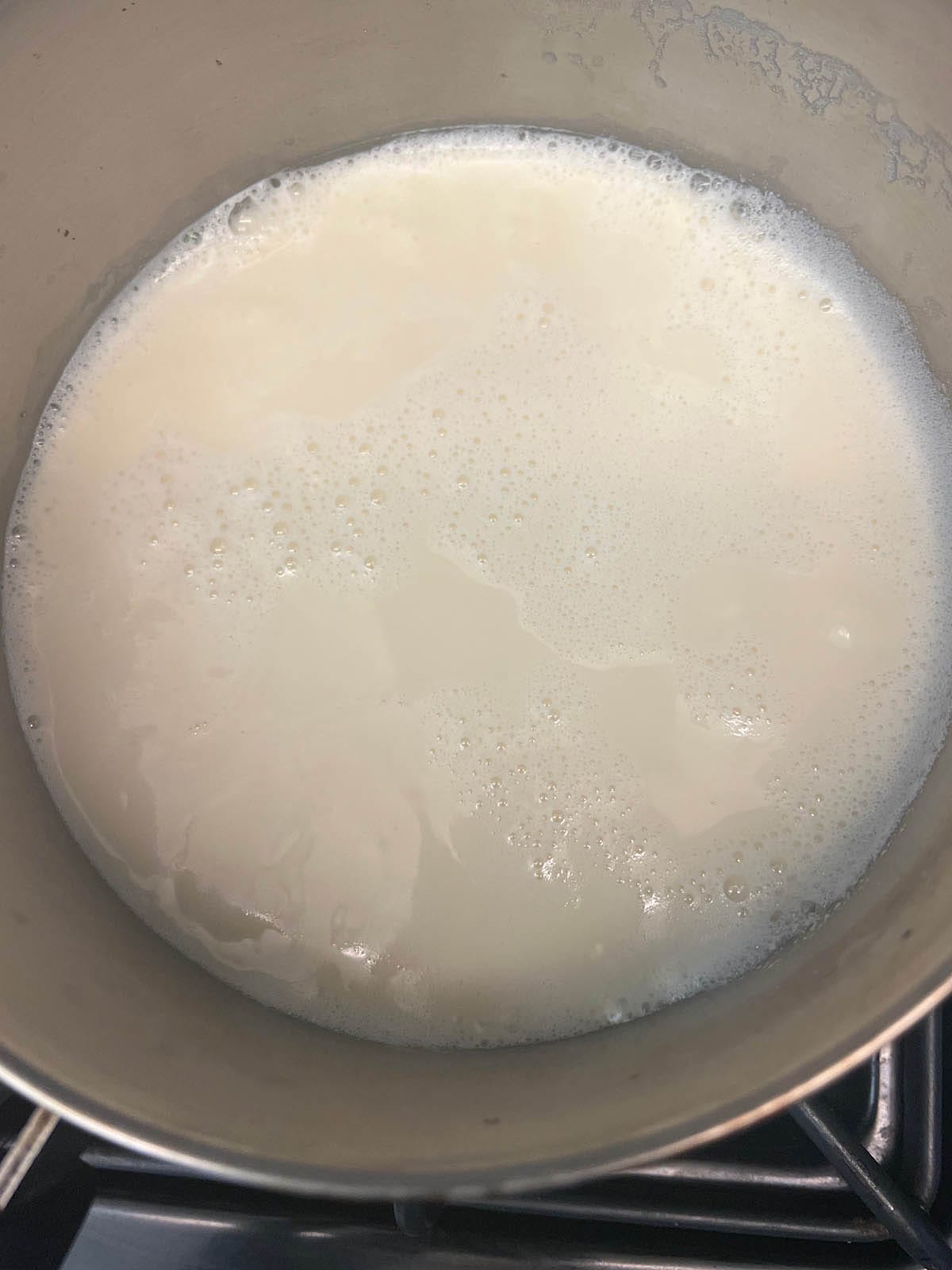 Almond milk boiling in a medium saucepan.