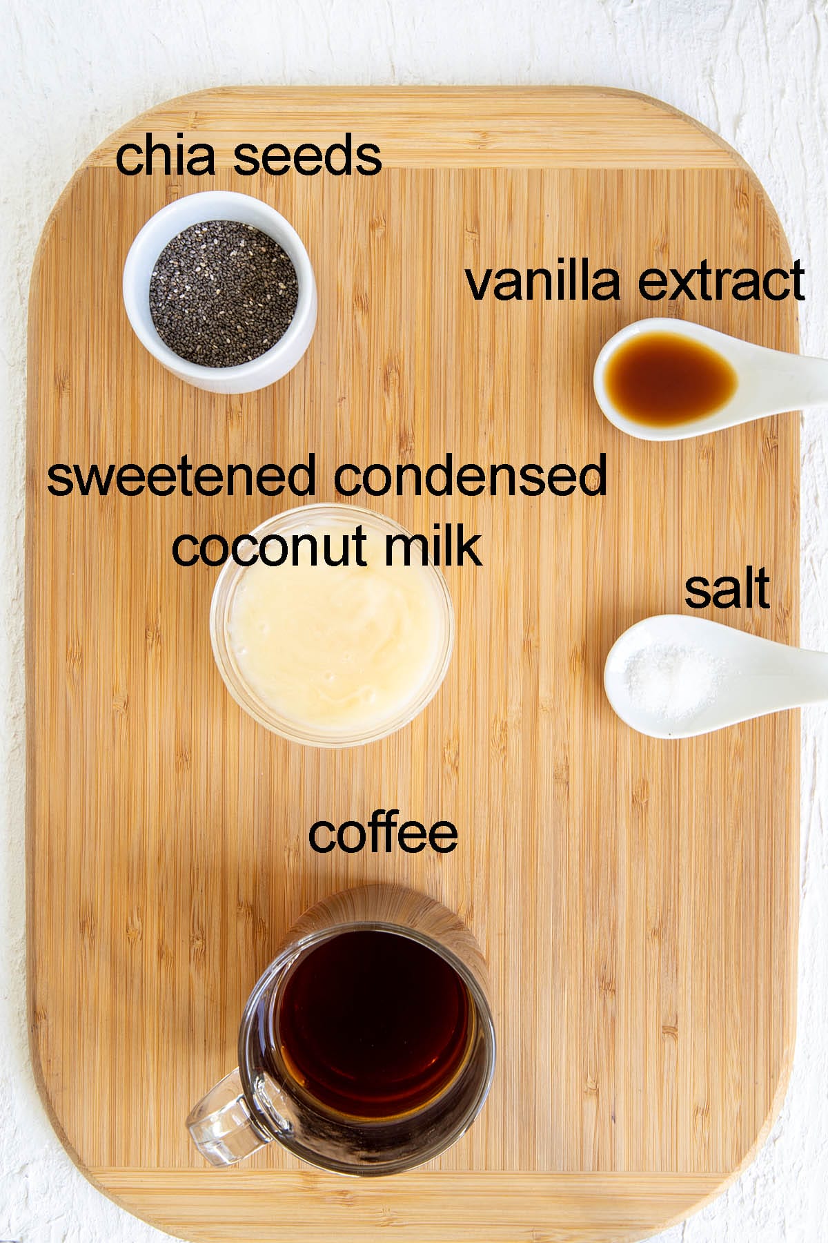 Ingredients for Thai coffee chia seed pudding on a cutting board with labels.