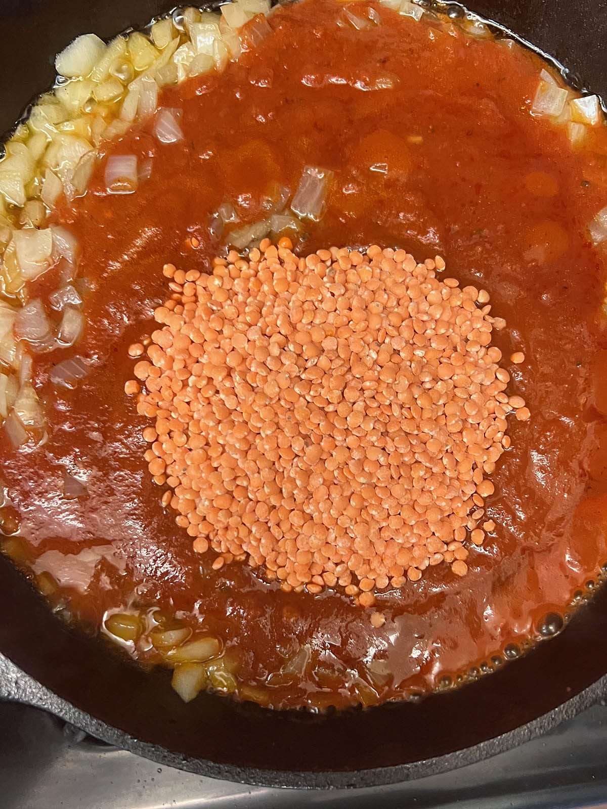 Lentils and marinara sauce added to the skillet.