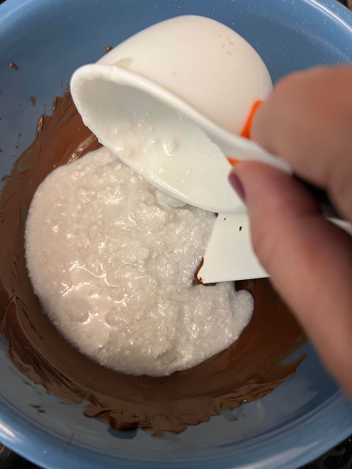 Coconut milk being added to the melted chocolate.