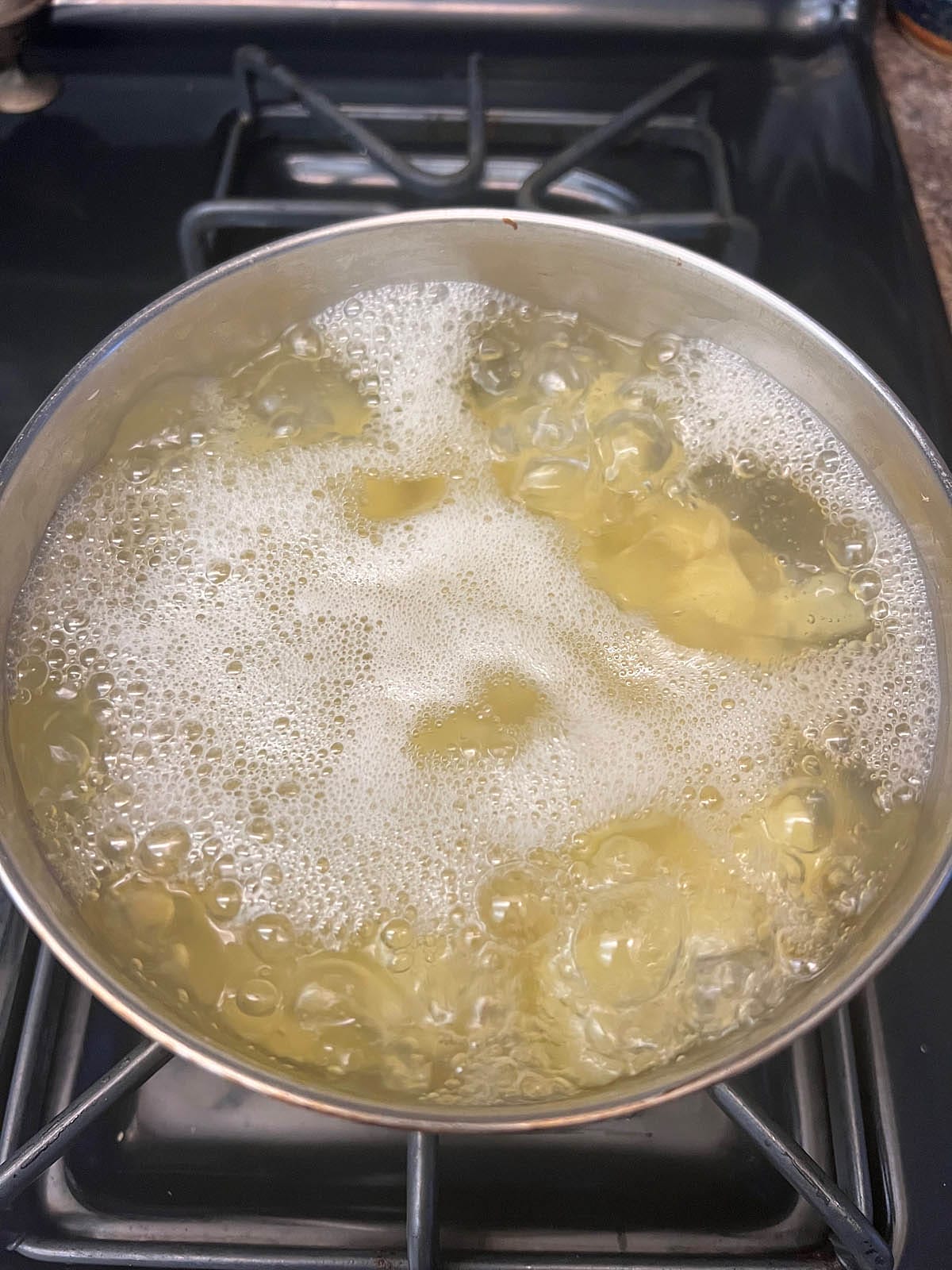 Potatoes in boiling water in a saucepan.