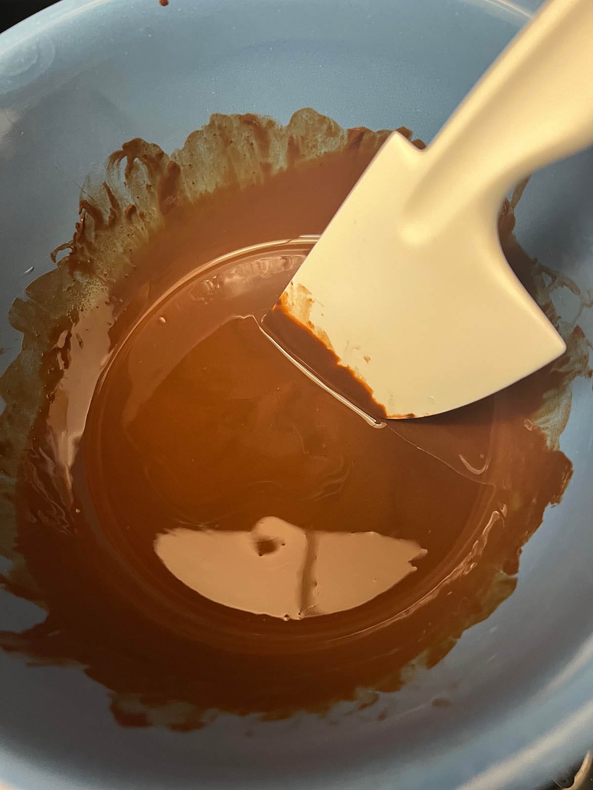 Melted chocolate in a bowl with spatula.