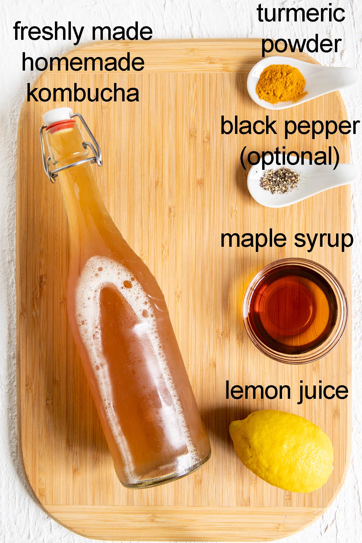 Lemon turmeric kombucha ingredients on cutting board with labels.