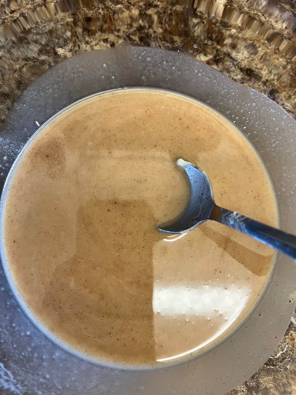 Nog mixture in a bowl with spoon.
