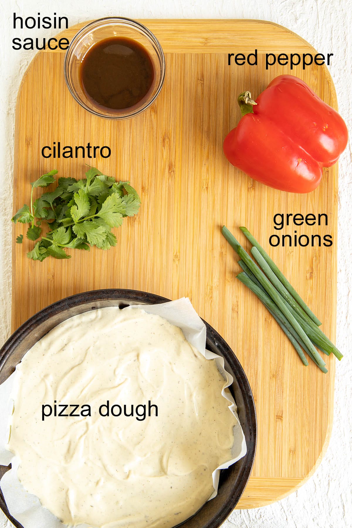 Chinese pizza ingredients on a cutting board with labels.