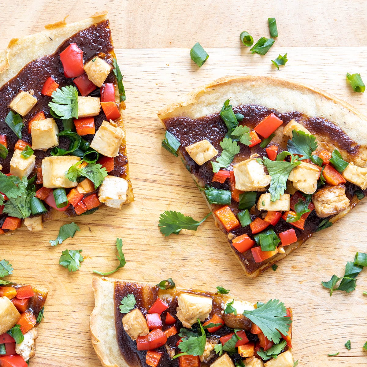 Slices  of Chinese pizza on a cutting board.