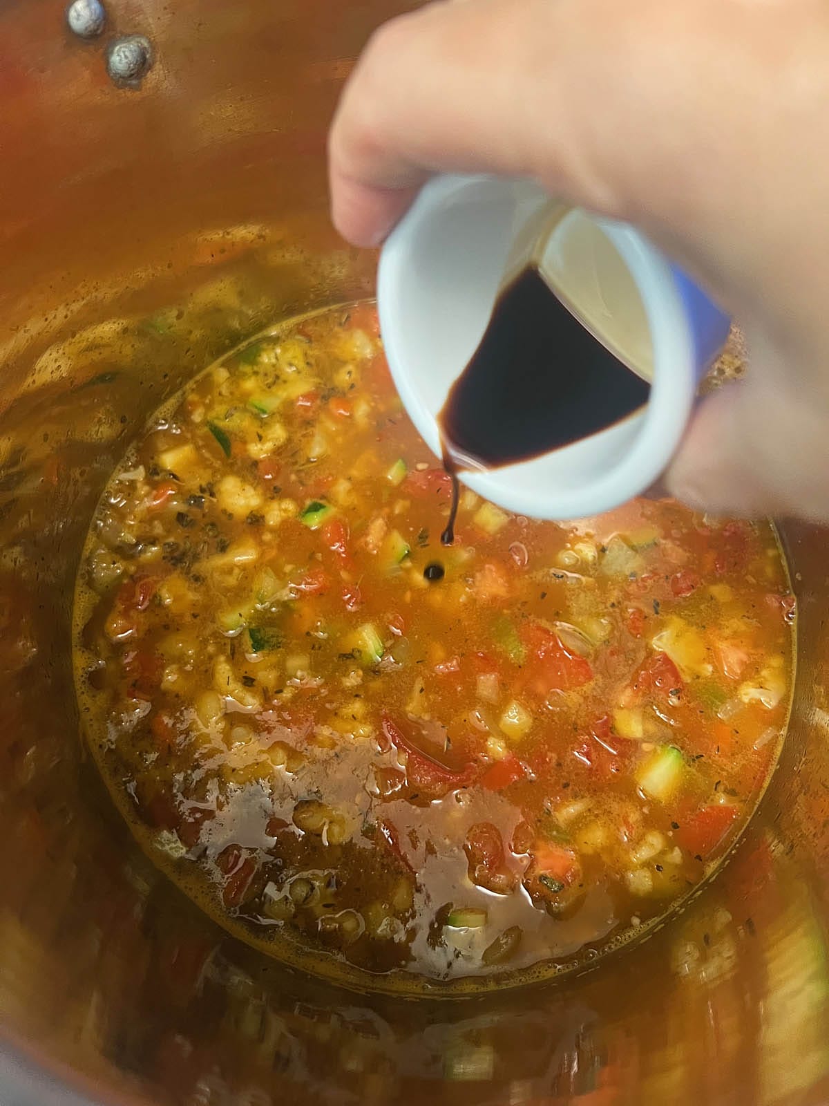 Balsamic vinegar being poured into the pot.