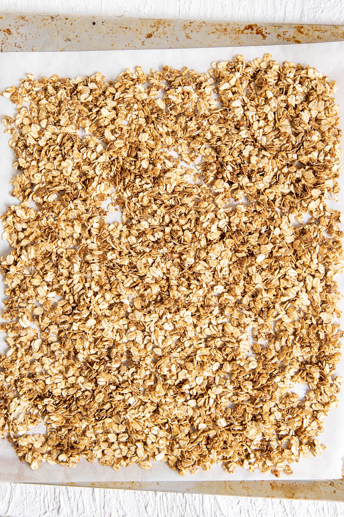 Rolled oats on a parchment paper lined baking sheet.