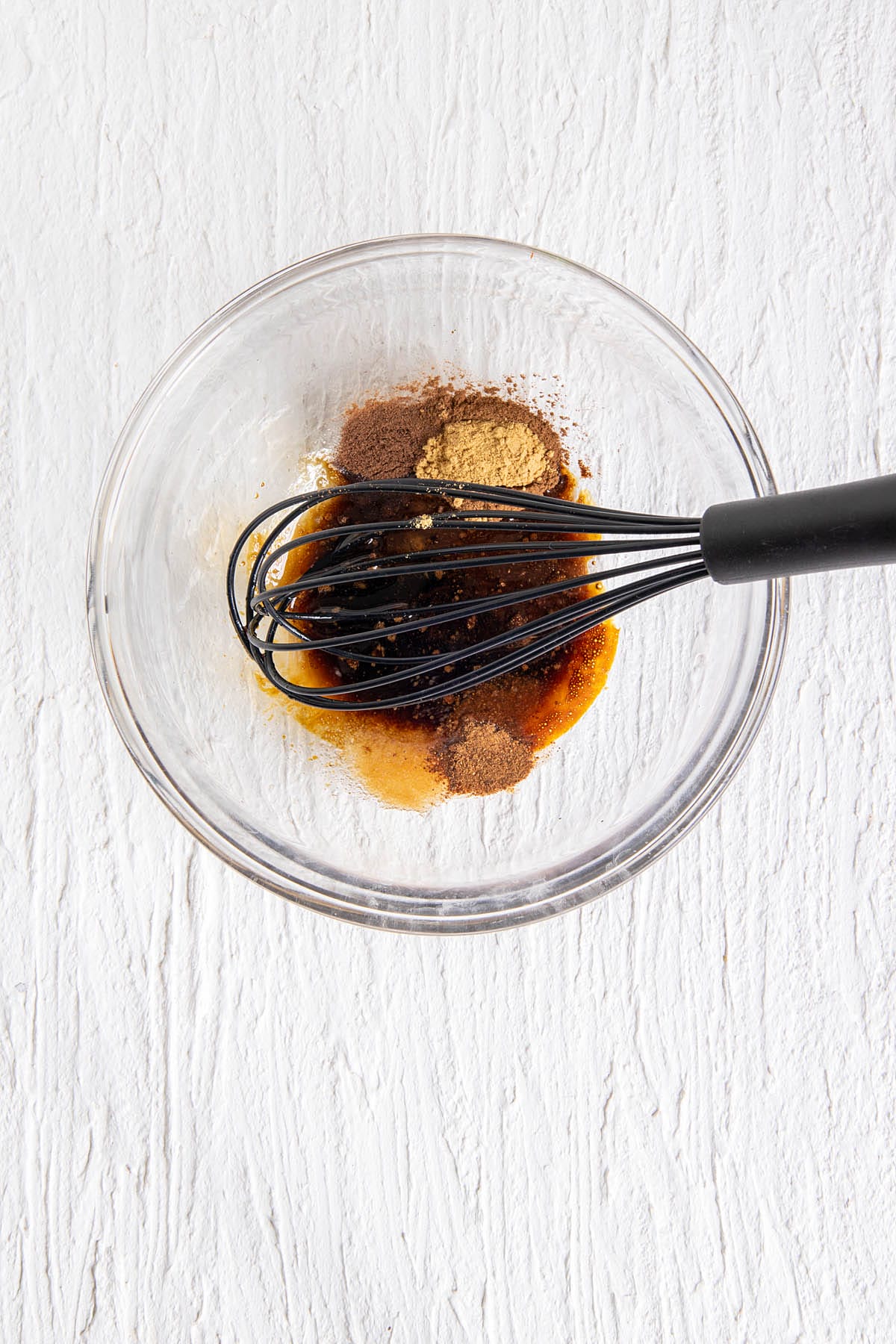 Wet ingredients and spices in a large bowl with whisk.