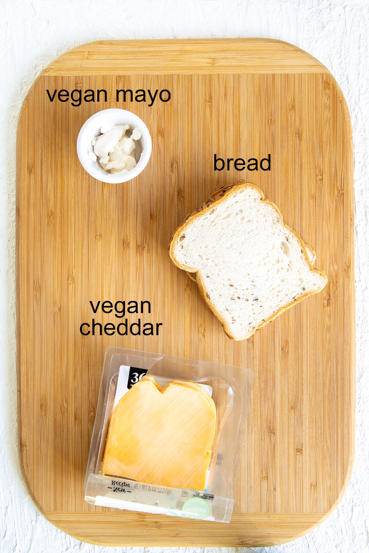 Ingredients for refried bean grilled cheese on a cutting board with labels.