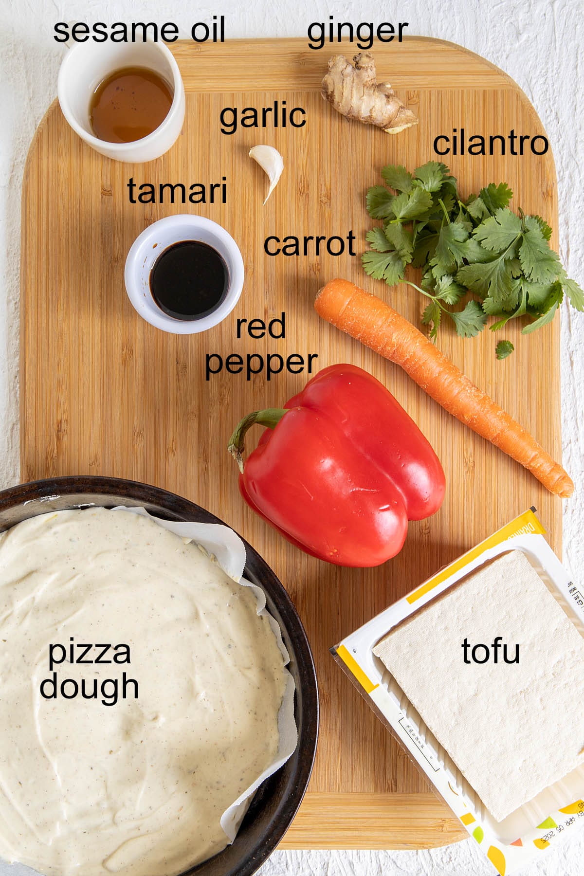 Thai Pizza ingredients on a cutting board with labels.