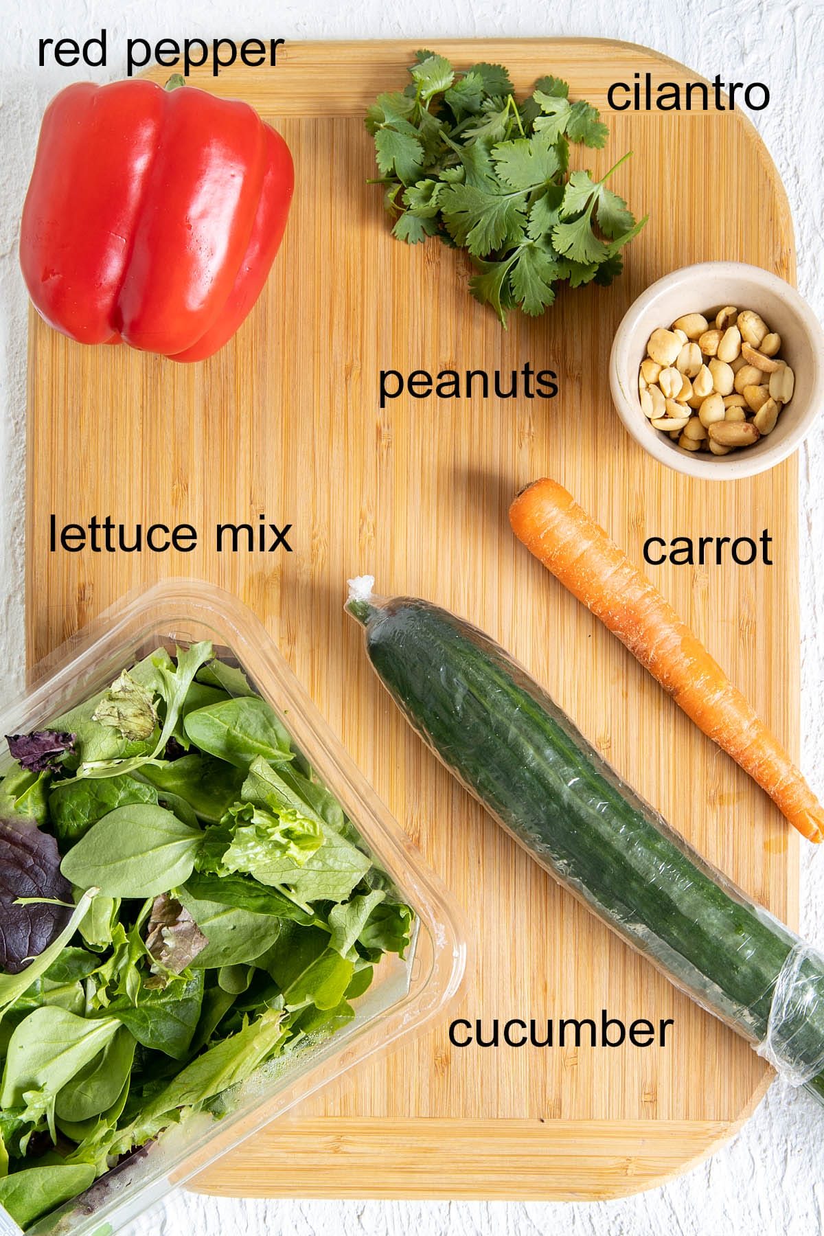 Thai salad ingredients on a cutting board with labels.