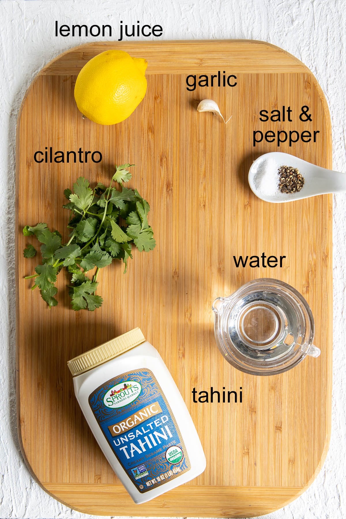 Cilantro Tahini Dressing ingredients on a cutting board with labels.