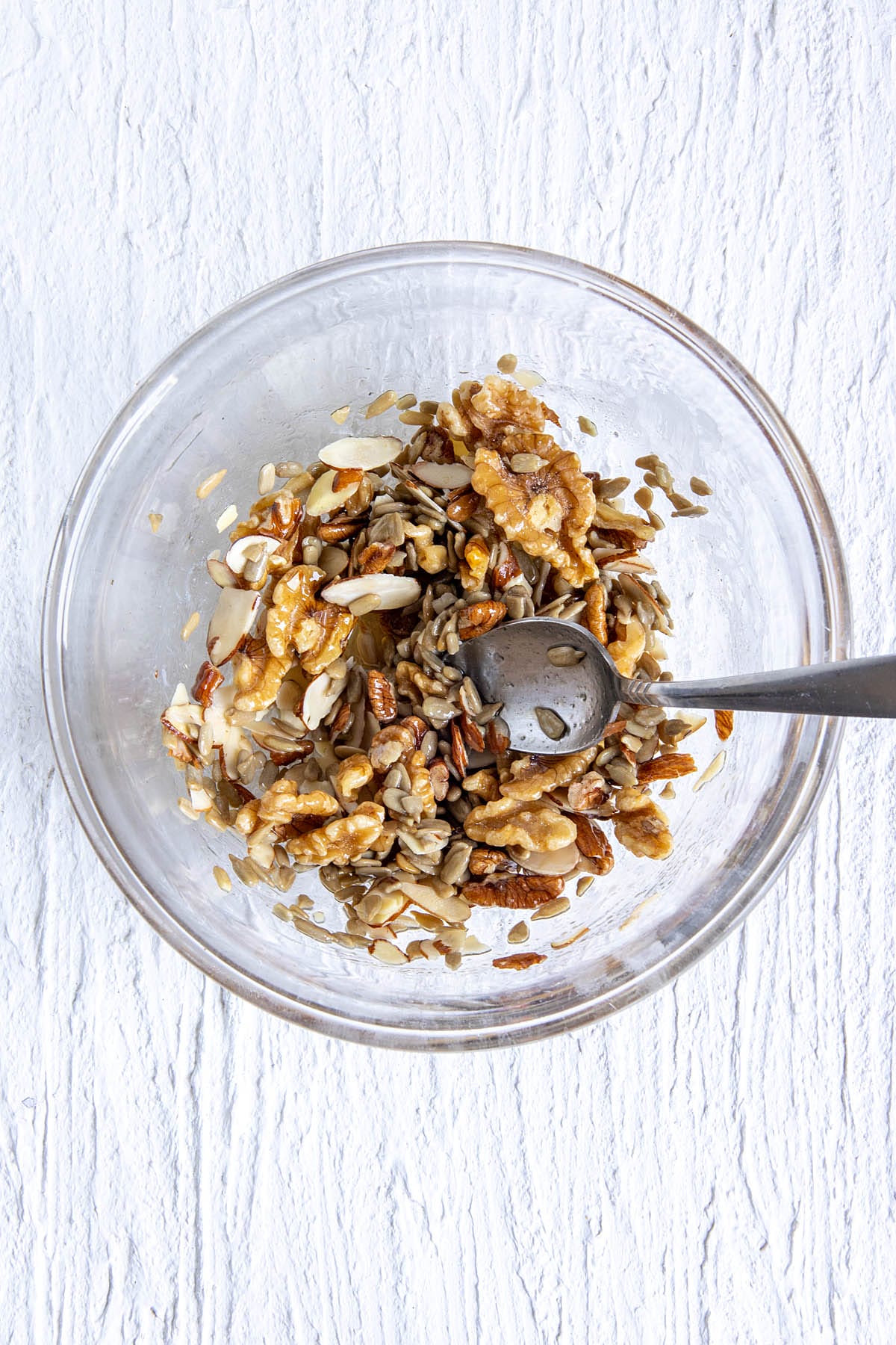Nuts and seeds in a mixing bowl with wet ingredients.