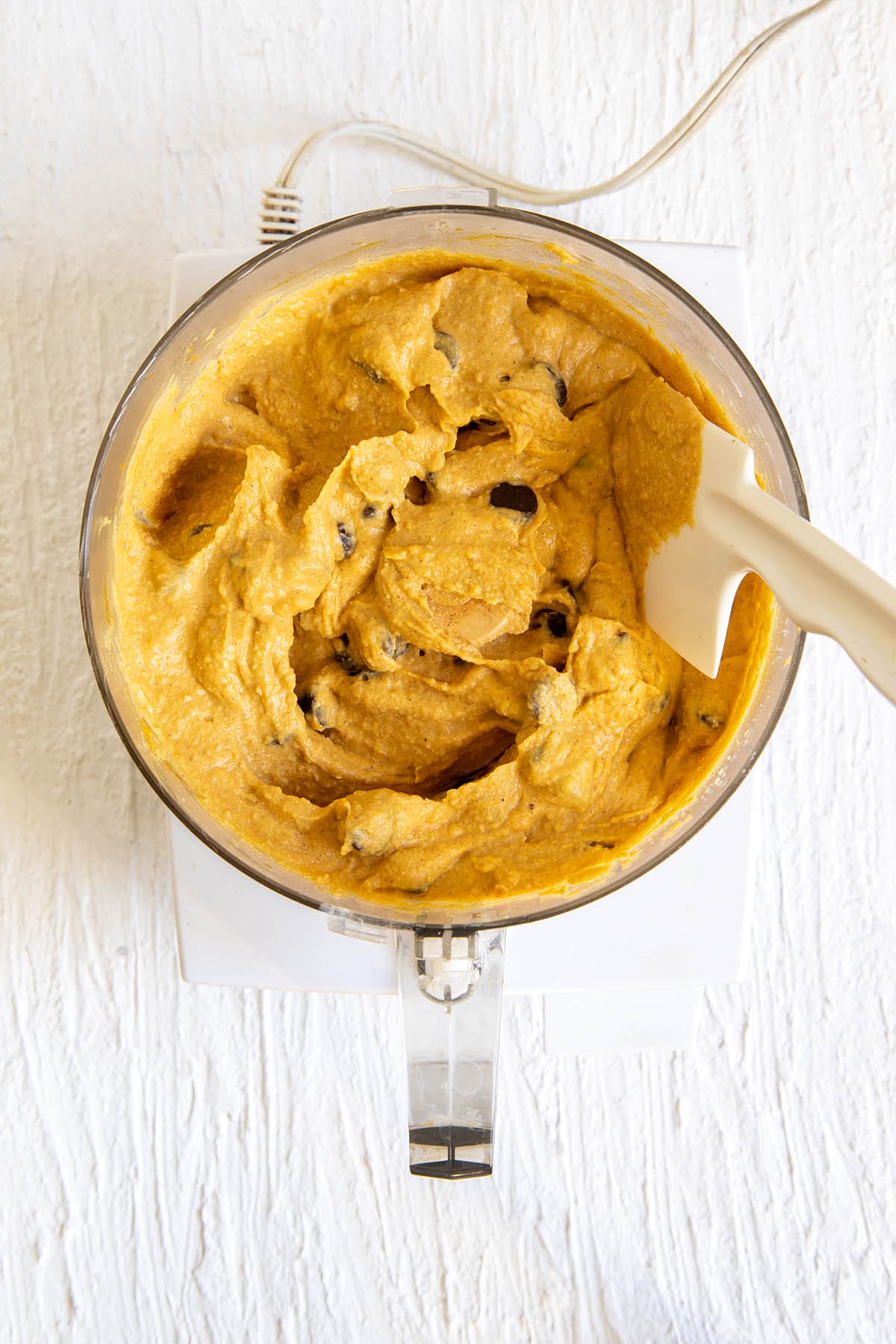 Chocolate chips folded into the pumpkin chickpea blondie mixture in a food processor.