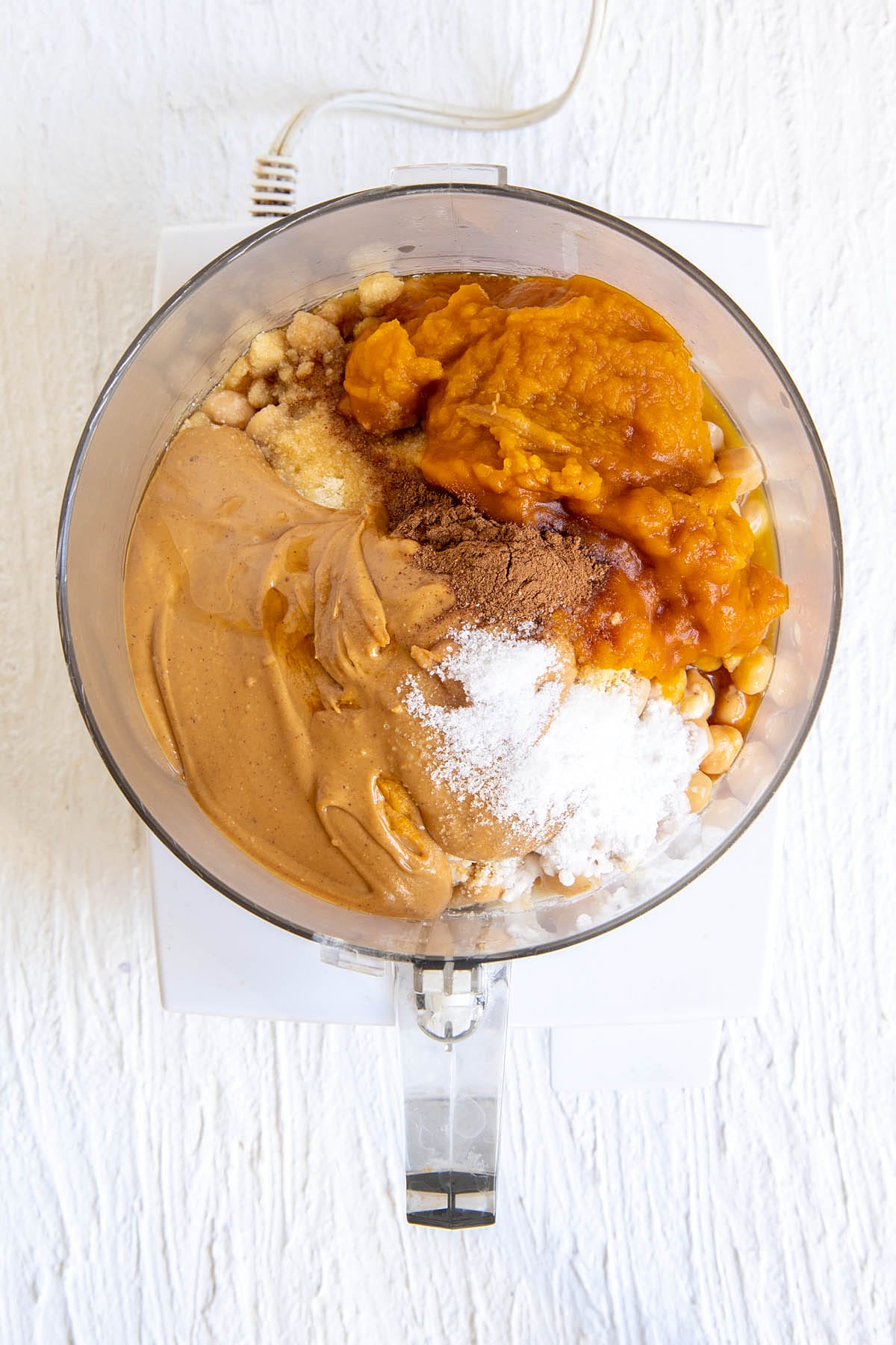 Pumpkin chickpea blondies ingredients in a food processor before mixing.